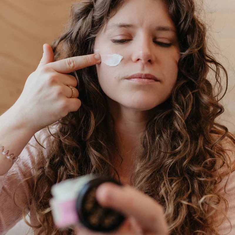 good flower farm moisturizing rose geranium face cream being applied to womans cheek