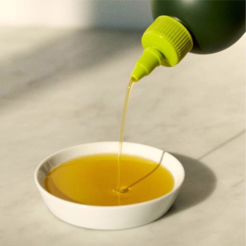 graza sizzle extra virgin olive oil in 750ml squeeze bottle with yellow label pouring into dish